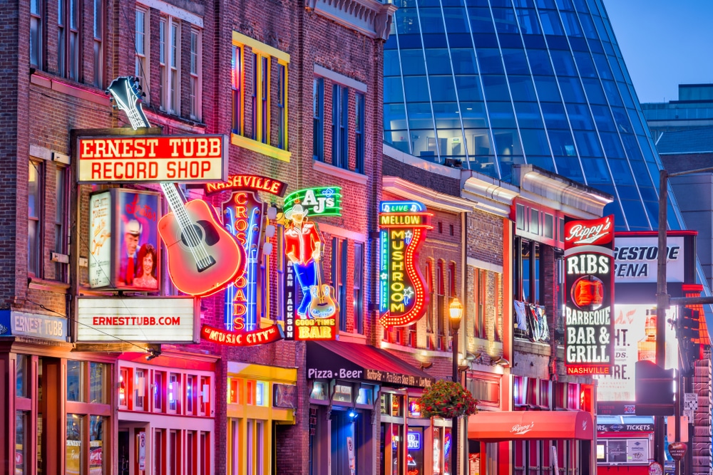 Neon signs of honky-tonks along Broadway Street in downtown Nashville at night